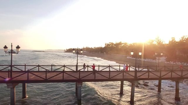 sunset from drone beautiful view of pier and couples walking on it. 
filmed on golden mile (milla de oro) marbella, spain.