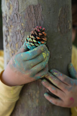 the child paint her hands and hug the tree with finger paint.