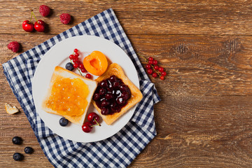 Breakfast. Toasts with cherry or peach jam and fresh fruit.
