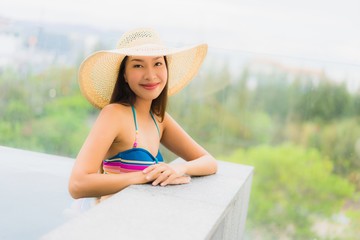 Portrait beautiful young asian woman smile happy relax around swimming pool in hotel resort for leisure