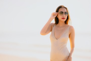Portrait beautiful young asian woman smile happy walk on the tropical outdoor nature beach sea