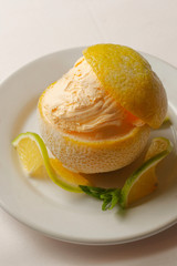 Dessert of orange ice cream wrapped in peel.