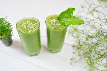 Blended green smoothie with ingredients or cocktail on white background, breakfast vegan with a place for your text, concept of raw food detox