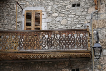 old carved wooden deck and stone facade in the Alps, France