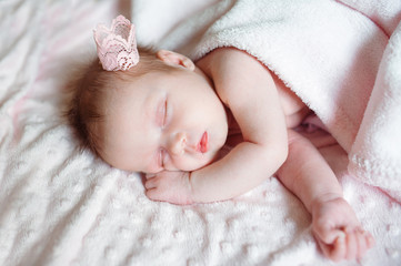 lovely newborn girl sleeping on pink blanket with place for your text