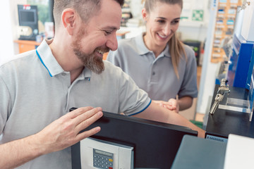 Seller in his shop with customer selling a safe