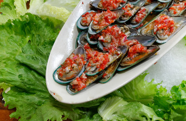 Oysters in their shell with tropical red sauce.