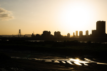 silhouette of buildings with river at sunset