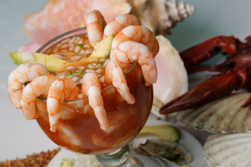 Fresh shrimp cocktail with onion, cilantro, avocado and lemon in tomato sauce.