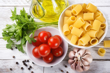 Pasta and ingredients on white wood background: Top view