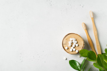 Zero waste and minimalism concept. Wooden ecological toothbrushes and toothpaste tablet on white...
