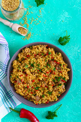 Bulgur with chicken and vegetables. Delicious healthy warm salad on a bright background. Bulgur pilaf. Top view, flat lay.