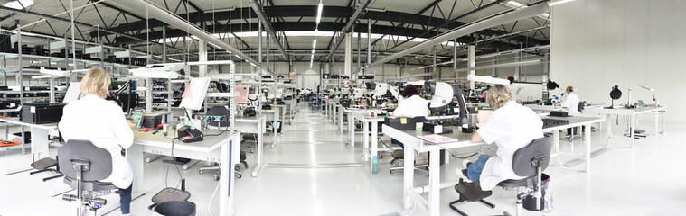 workers in a factory for the production of electronics - modern industrial enterprise