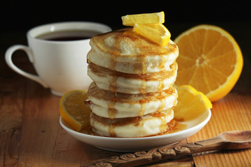 A stack of freshly backed pancakes and a cup of coffee