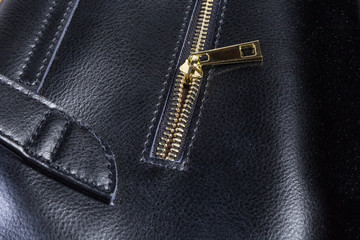 Fragment of zipper of the black women handbag close-up