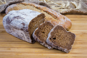 Two varities of brown bread on wooden surface close-up