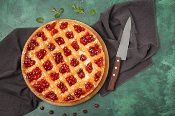 Tasty cranberry pie and knife on table