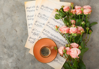 Cup of coffee with music notes and beautiful roses on grunge background