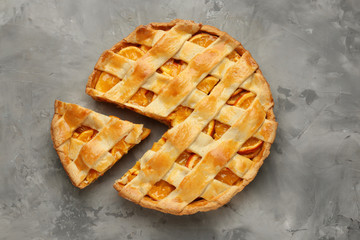 Tasty orange pie on grey background