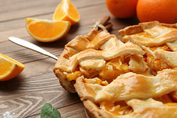 Tasty orange pie on wooden table, closeup