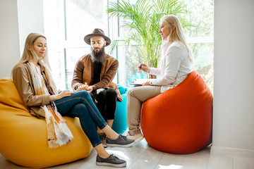 Young happy couple during the psychological counseling with senior female psychologist or mental...