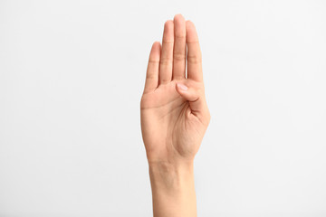 Female hand showing letter B on light background