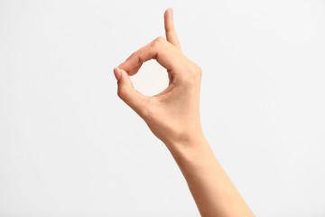 Female hand showing letter D on light background