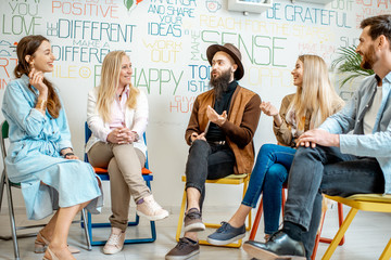 Young people sitting together during the psychological therapy, solving together some mental...