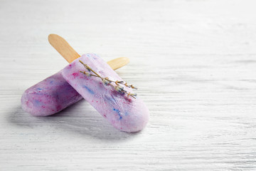 Tasty lavender ice cream on white wooden background