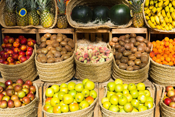 vegetables and fruits in wicker baskets on counter of greengrocery