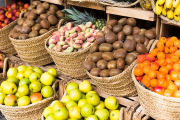 vegetables and fruits in wicker baskets on counter of greengrocery