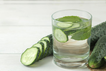 water with cucumber. Refreshing diet water with cucumber in a glass cup on a light background. detox drink concept. summer refreshing drink.