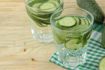 water with cucumber. Refreshing diet water with cucumber and mint in a glass beaker on a wooden background. detox drink concept. summer refreshing drink.