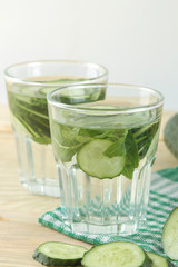 water with cucumber. Refreshing diet water with cucumber and mint in a glass beaker on a wooden background. detox drink concept. summer refreshing drink.