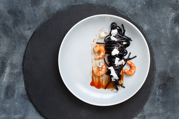 Squid ink pasta with prawns and tomatoes