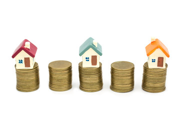 Mini house on stack of coins, Real estate investment concept and real estate business growth isolated on white background.