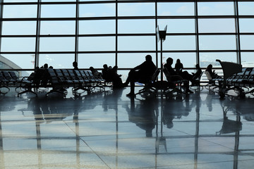 Silhouettes of people in airport. People waiting for departure
