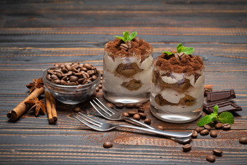 two portions Classic tiramisu dessert in a glass on wooden background