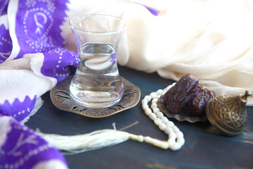 Iftar. Traditional food set to start evening meal during Ramadan fasting. Hot water in oriental glass, date fruits  on a wooden table.