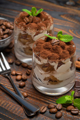 two portions Classic tiramisu dessert in a glass on wooden background
