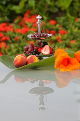 Fruit cocktail with grapes, plum, strawberry and peach served in a silver bowl.