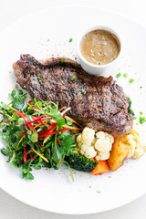 premium beef steak with steamed vegetables meal on white plate