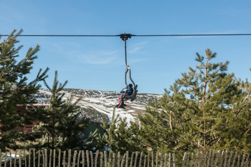 Side view of a chairlift with people