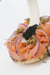 Fresh salmon on brioche bread with olives, capers and caviar.