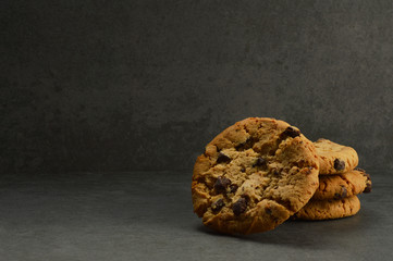 Chocolate chip cookies on black stone background
