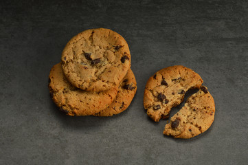 Chocolate chip cookies on black stone background