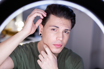 Self-confident handsome man with flawless skin posing on camera