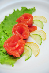 Fresh salmon decorative roses fillets, with lemon slices on the plate
