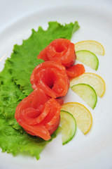 Fresh salmon decorative roses fillets, with lemon slices on the plate