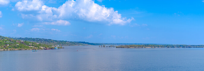 Beautiful summer river landscape - with a horizon panorama, water and blue sky, summer background, copy space